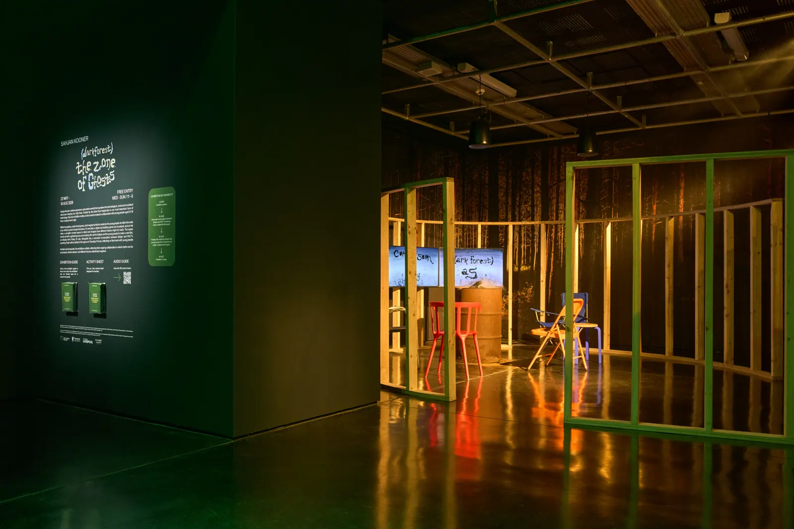 The entrance to The Zone of Ghosts installation, with coloured wooden framing reflected on the dark gallery floor