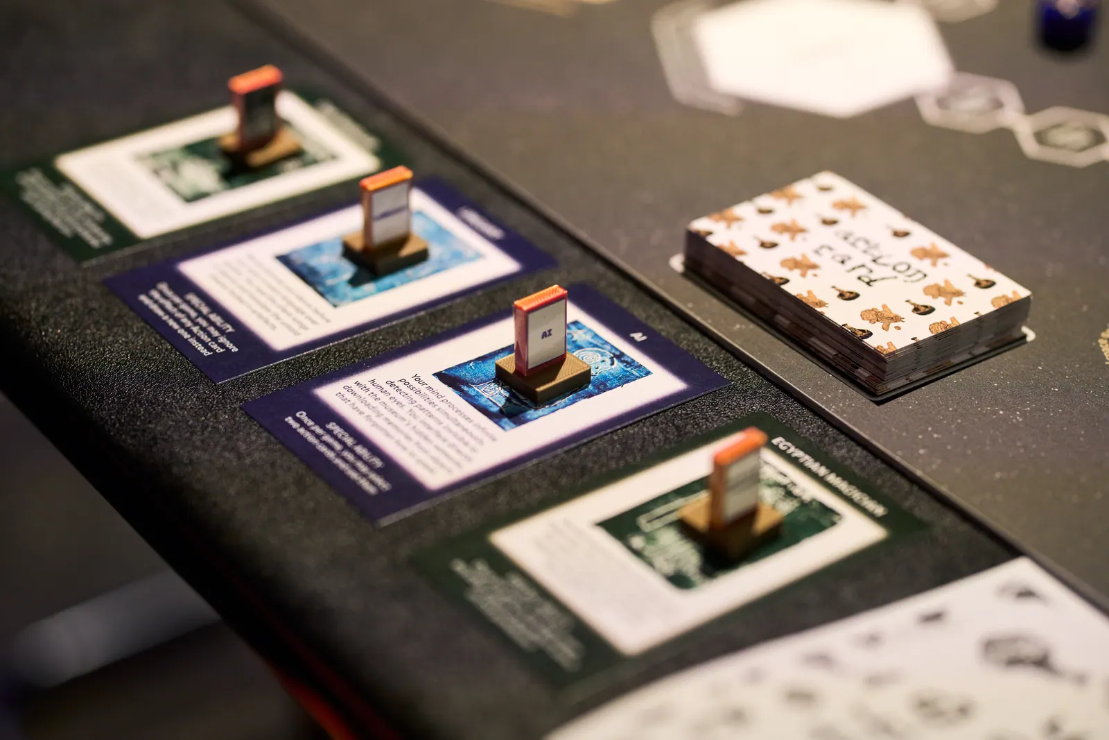 Cards, wooden pieces and small illustrated decks arranged for The Zone of Ghosts tabletop game