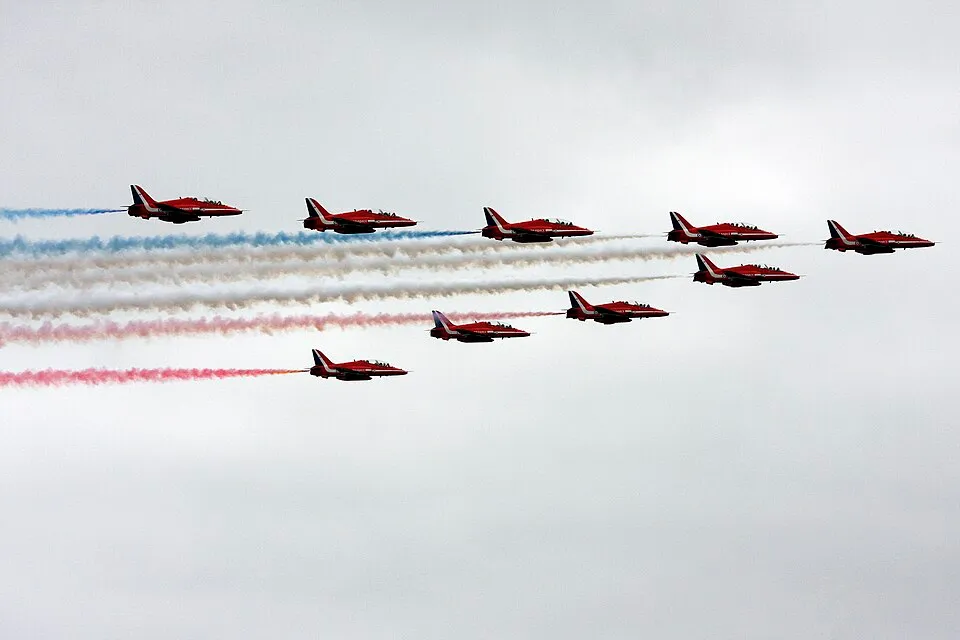 The Red Arrows in tight formation trailing red, white and blue smoke over Southport seafront
